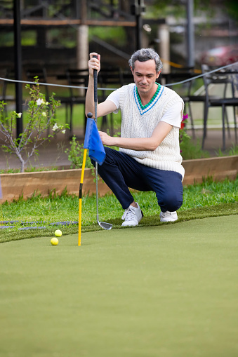 Man calculating his shot in mini golf