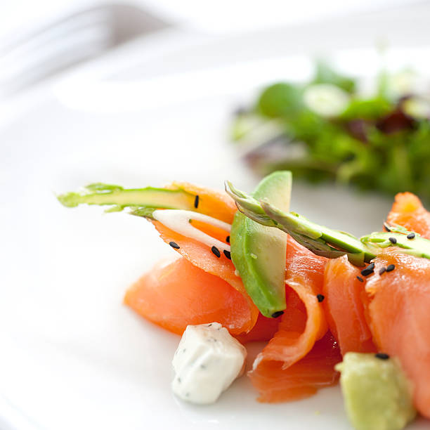 Close up of smoked salmon salad with green asparagus and avocado