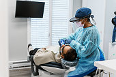 Female dentist performs a tooth filling on a patient