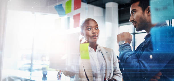 istock Creative people, planning and thinking in meeting for schedule brainstorming and strategy at the office. Man and woman in teamwork decision for project plan, tasks or sticky note ideas in startup 1554632023