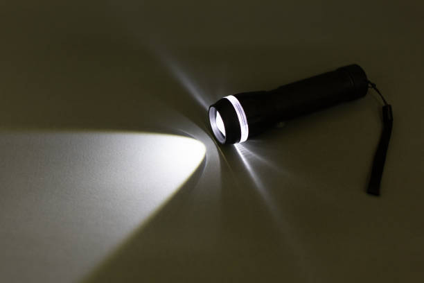 istock Black torch or flashlight with beam of light. 1554647940