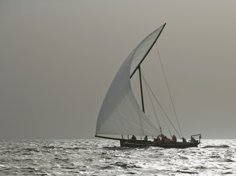 A traditional racing dhow in the Arabian Gulf moonlight off Dubai.