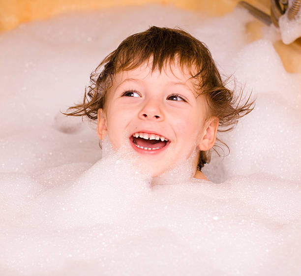 mignon petit garçon dans la salle de bain en mousse - soap sud water froth bubble photos et images de collection