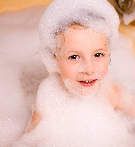 mignon petit garçon dans la salle de bain en mousse - soap sud water froth bubble photos et images de collection