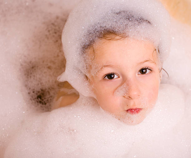 mignon petit garçon dans la salle de bain en mousse - soap sud water froth bubble photos et images de collection