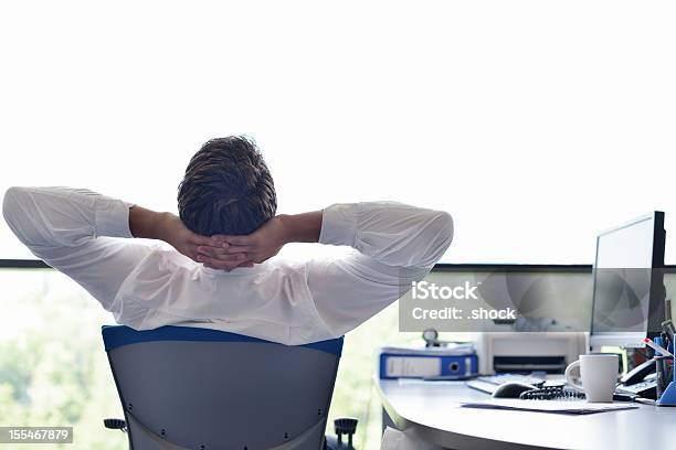 A Happy Young Business Man Relaxing At His Office Stock Photo - Download Image Now - Businessman, Cheerful, Freedom