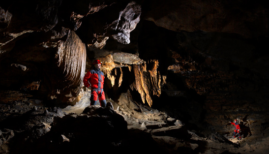 Cave explorers in one of halls of a cave the Victory. Russia, south Ural.
