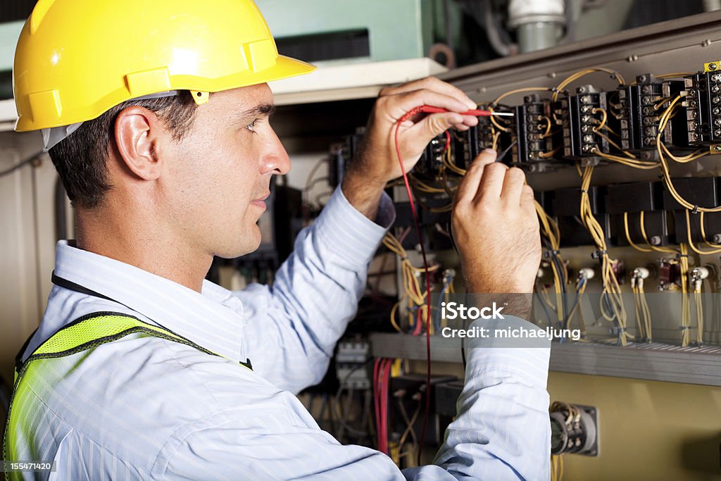 Electrician working on a circuit board male professional electrician testing industrial machine Electrician Stock Photo