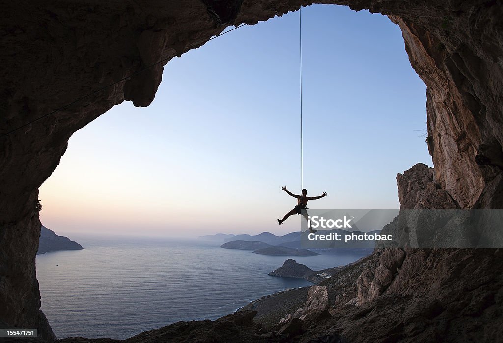 Rock climber at sunset - Foto de stock de Escalada en roca libre de derechos