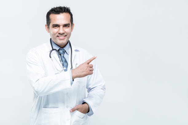 istock man doctor pointing with hand and finger up to the side 1554765273