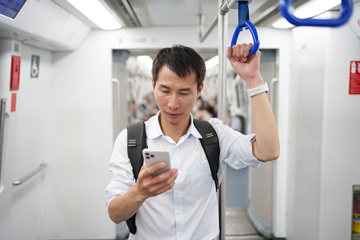 Men using mobile phones on the subway