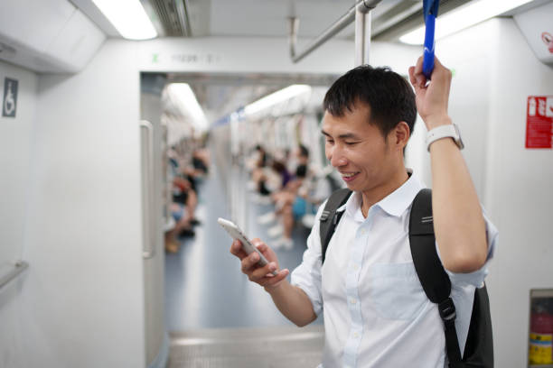 istock Men using mobile phones in subway carriages 1554803307