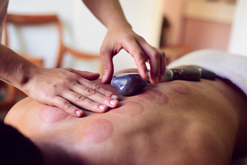 Getting hot stone massage in spa salon. beauty treatment concept.