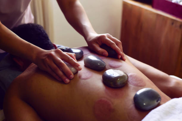 istock Getting hot stone massage in spa salon. beauty treatment concept. 1554805470