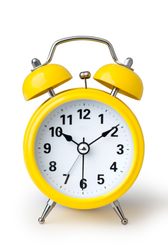 A yellow alarm clock isolated on a white background