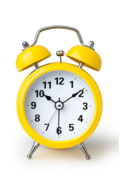 Alarm Clock A yellow alarm clock isolated on a white background alarm clock stock pictures, royalty-free photos & images
