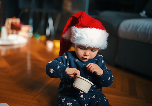 Cute little boy in Christmas costume siting on a floor and playing