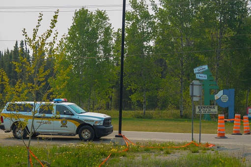 Lebel sur quevillon, Canada – June 02, 2023: A silver police car parked on the street in front of a series of orange traffic cones