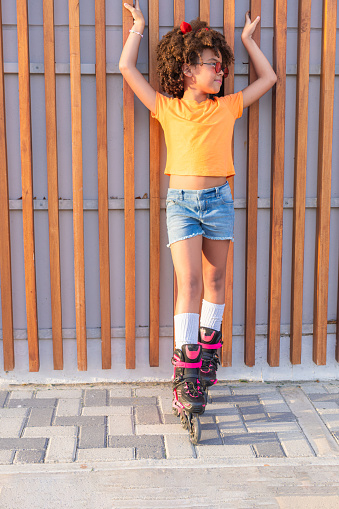 A young girl on roller skates in the street for a recreation concept.