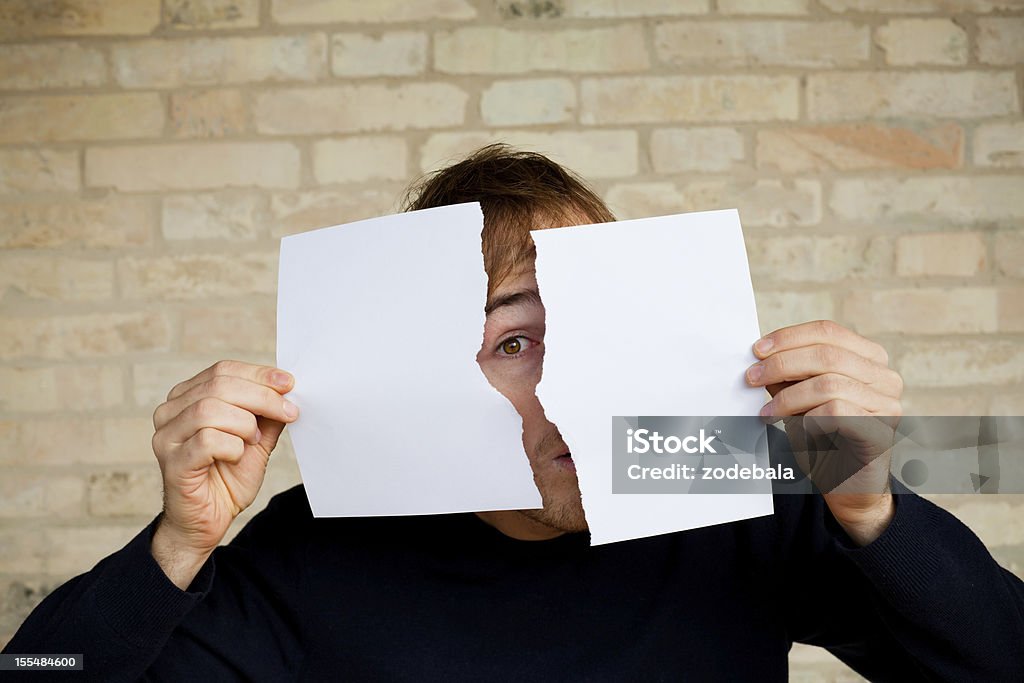 Young Man Holding y rasgar un papel en blanco - Foto de stock de Papel libre de derechos