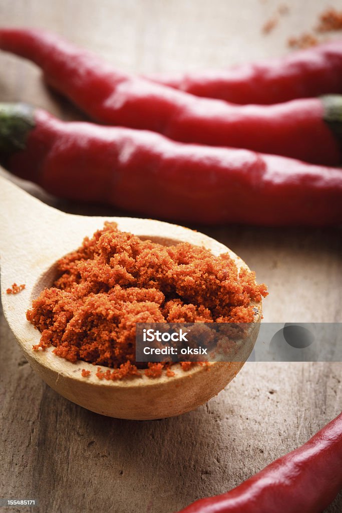 Pepper in wooden spoon Red hot chilli pepper in wooden spoon on table Cayenne Pepper Stock Photo