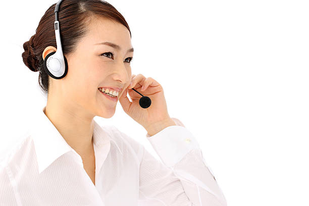 A smiling woman answering a call on her headset stock photo