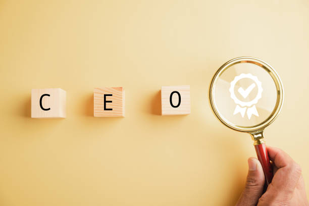 istock Human resources officer uses magnifying glass to find leader and CEO 1554865257