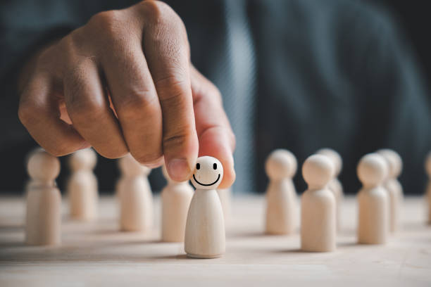 istock Man hand tightly grips wooden human figure 1554865822