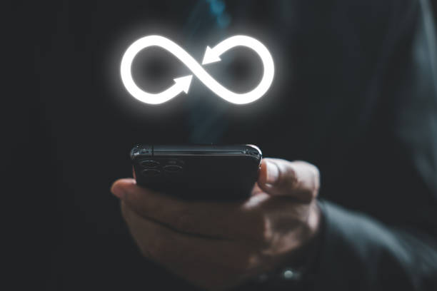 istock Businessman presents smartphone with infinity symbol 1554865852