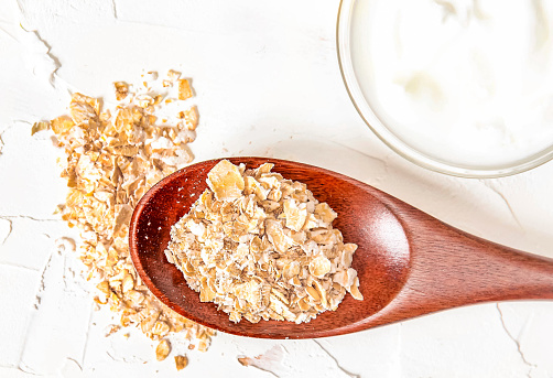 Homemade cosmetics with yogurt and oatmeal on a white background. Ingredients for the mask.