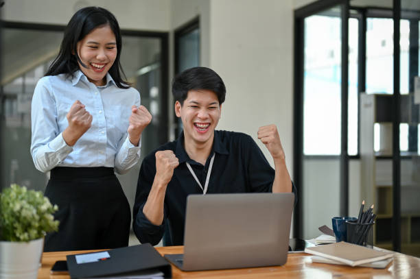 istock Two cheerful and overjoyed Asian office workers are celebrating their project success together 1554894303