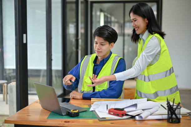 istock A smart male engineer is discussing a building blueprint on the desktop with his female colleague 1554895450