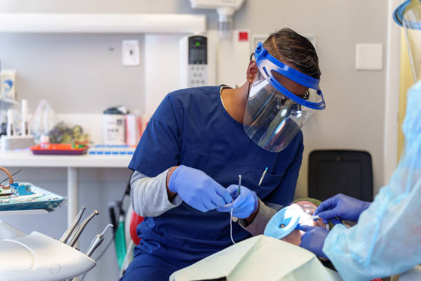 istock Male dentist conducts a procedure on a patient 1554903295