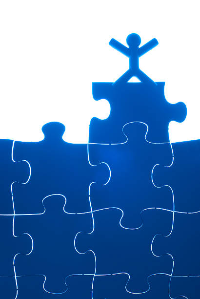 manos de una persona de aumento en la parte superior del rompecabezas. - portion blue jigsaw puzzle puzzle fotografías e imágenes de stock