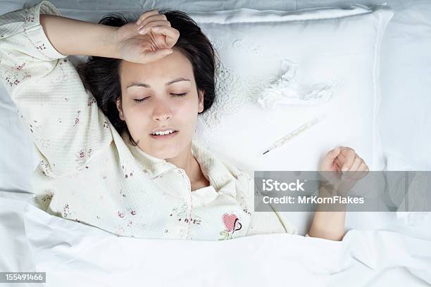 Sick Woman In Pajamas Resting On An Allwhite Bed Stock Photo - Download Image Now - 20-29 Years, 25-29 Years, Adult