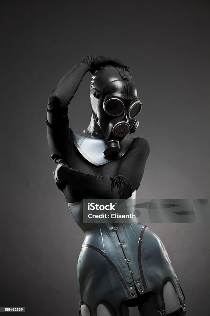 Woman in latex corset and gas mask Woman in latex corset and gas mask, studio shot on black background Gas Mask Stock Photo