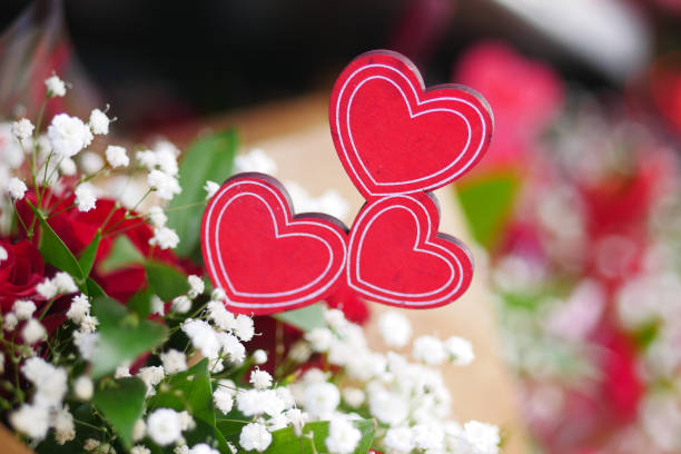 Two heart shapes made of red flowers, intertwined on a white background. Perfect for romantic, Valentine, wedding, and festive decoration concepts