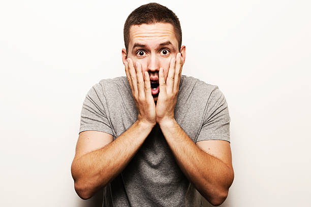 istock A man looking shocked with his hands on his face 155493109