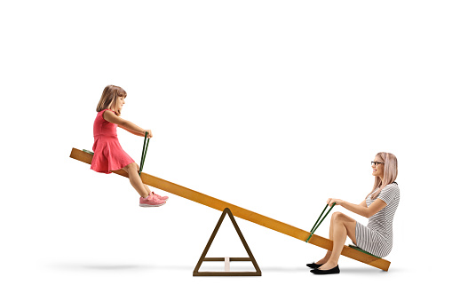Mother playing on a seesaw with a little girl isolated on white background