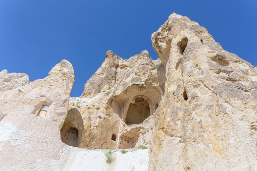 Entrance to the Dark church in volcanic landscape at Goreme Open air museum. Mediaeval monastery on cliffs, so-called 'Turkish Petra', famouse tourist attraction. Cappadocia, Turkey
