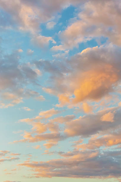 istock Beautiful fluffy clouds painted in bright painterly colors at sunrise. Multicolor vertical background or wallpaper 1554933827