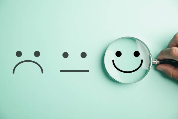 istock Magnifier in hand focuses on selected happy smiley face icon 1554949683