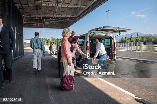 istock People Waiting For Luggage Standing Next To A Shuttle Van At The Airport 1554996045