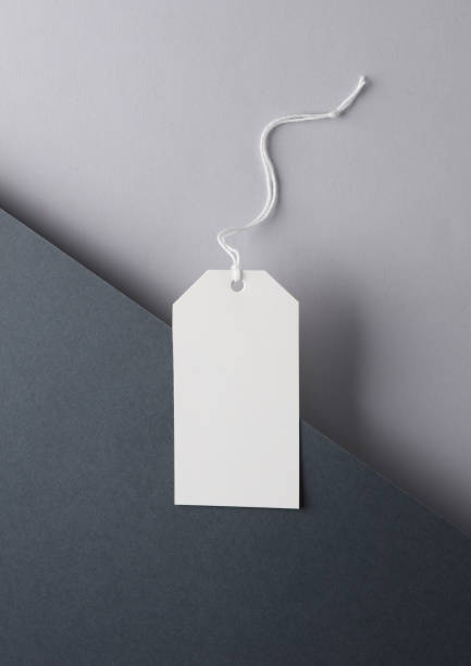 istock Blank price tag on black and gray background. Creative layout. Minimalism composition 1555043668