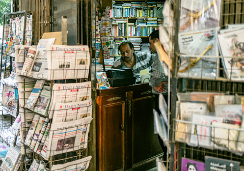 July 4th 2023,Cairo,Egypt:Locals buying newspaper from a store on the street in Zamalek, which is the most modern and posh area in Cairo.