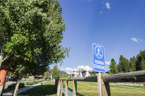 Remain Standing Sign at Jackson (Jackson Hole) in Teton County, Wyoming. This refers to the funicular ropeways related. Hotels and other commercial locations can be seen in the background.