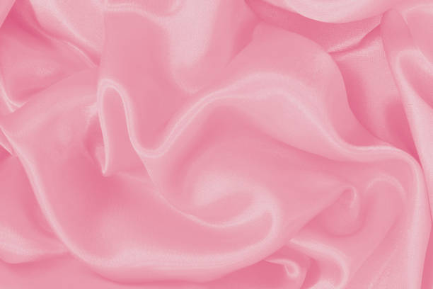 istock Soft pink fabric texture background, detail of silk or linen pattern. 1555069496