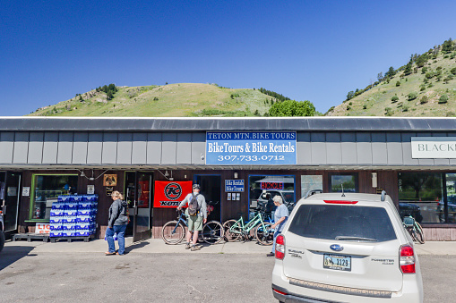People walk around Teton Mountain Bike Tours, a bike rental operator, on North Cache Street at Jackson (Jackson Hole) in Teton County, Wyoming
