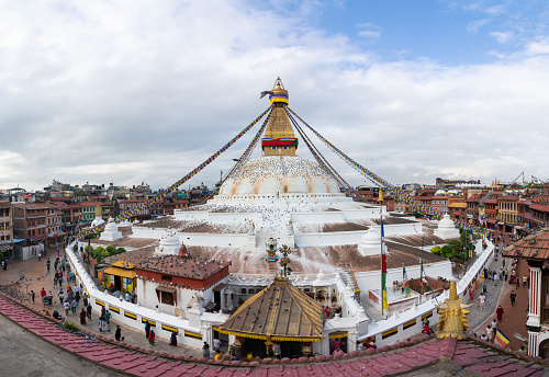 Elevated close-up of Buddhist temple with wisdom eyes, prayer flags, and massive mandala making it one of the largest spherical stupas in Nepal and the world.