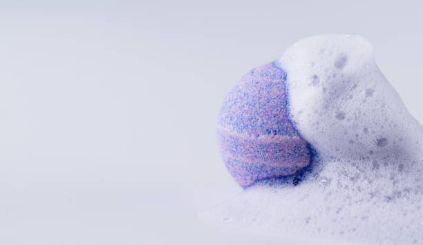 istock Purple bath bomb with soap on white background. 1555102709